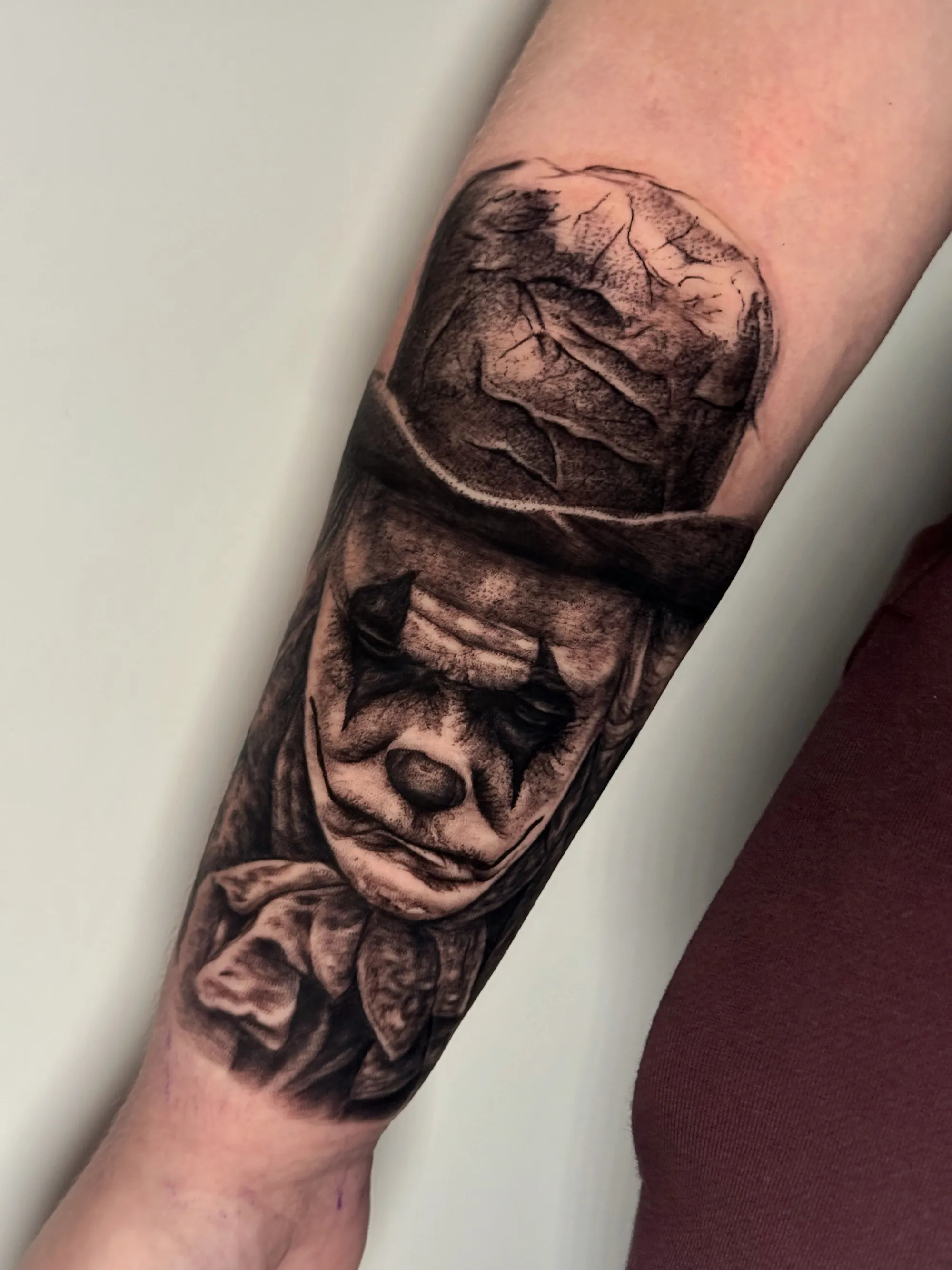 Realistična crno-bela tetovaža lica tužnog klovna na podlaktici,  Dropz Tattoo Studio Niš